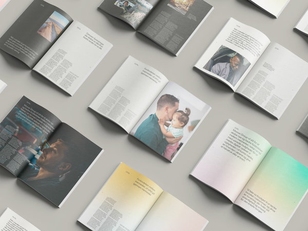 A collection of open magazines spread out on a surface, displaying various pages with text and images including photographs of people, objects, and colored backgrounds. The arrangement provides a glimpse into the diverse content within the magazines.